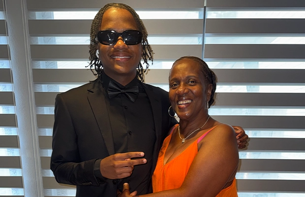 young boy using glasses posing next to a lady
