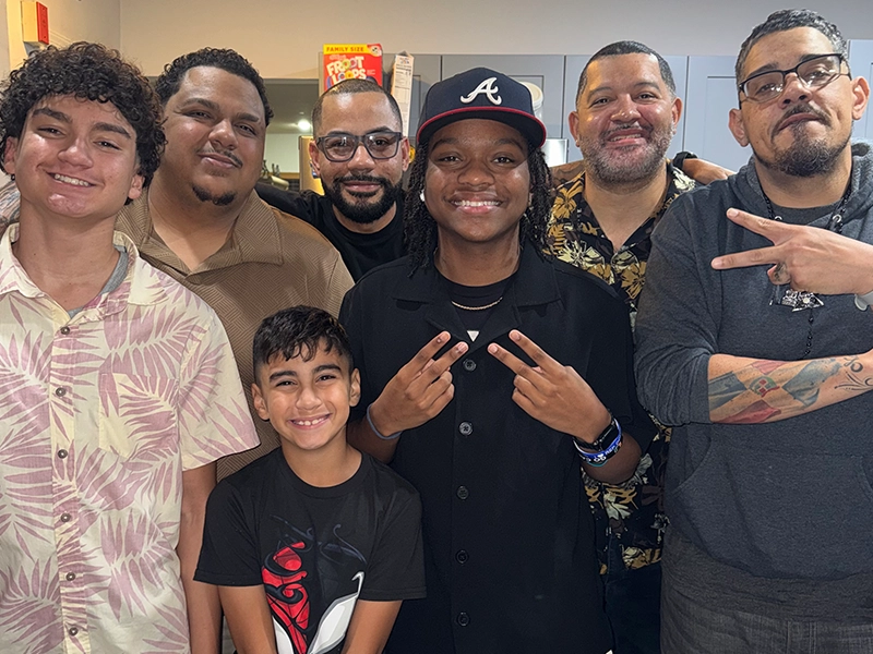 Six men and a boy posing and smiling at the camera.