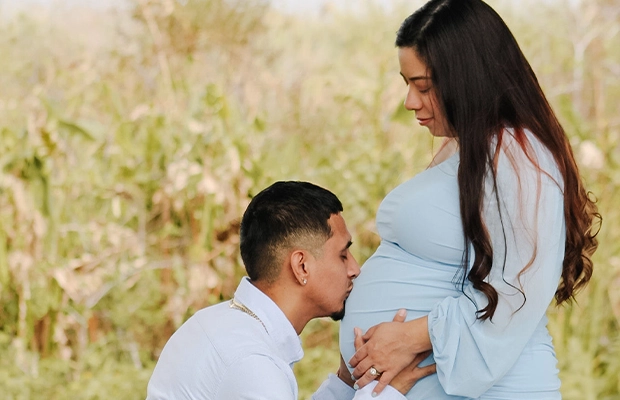 Man kissing his pregnant partner's belly