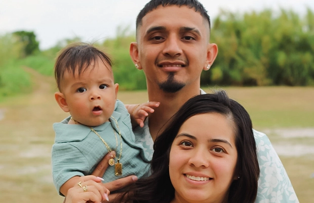 A couple with their young son smiling at the camera