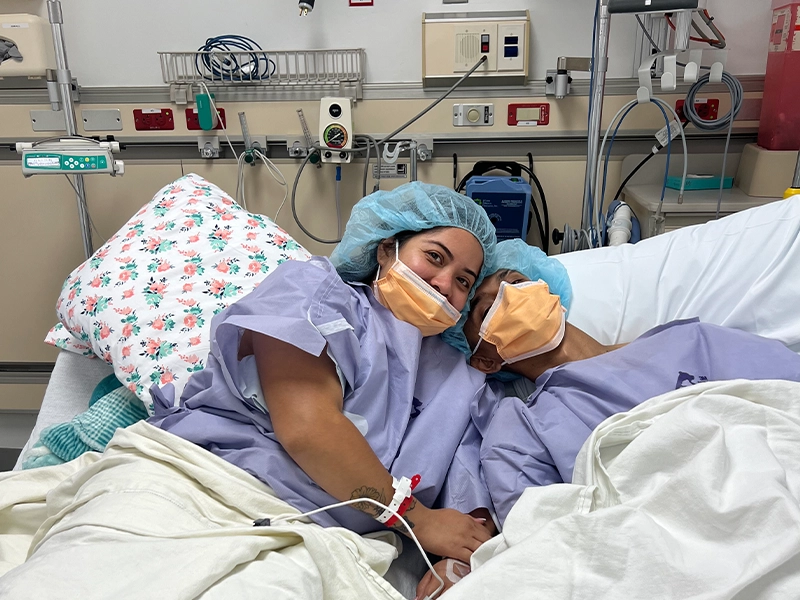A couple lying on a hospital gurney before an operation