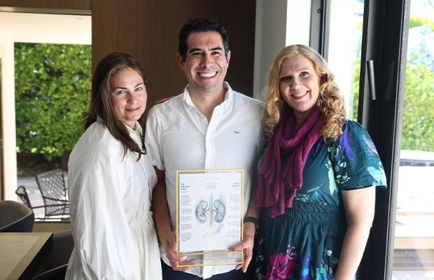 three people posing and smiling at the camera