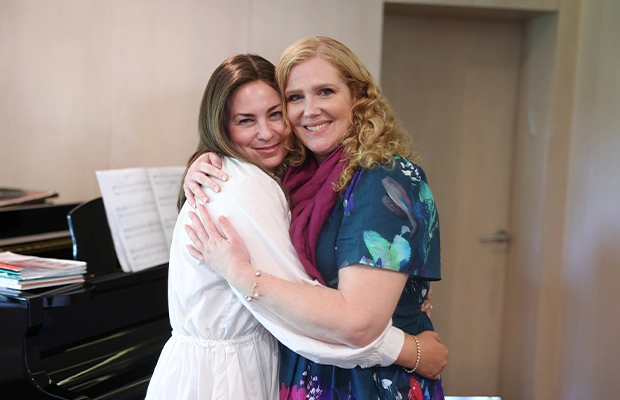 two women embracing and smiling at the camera