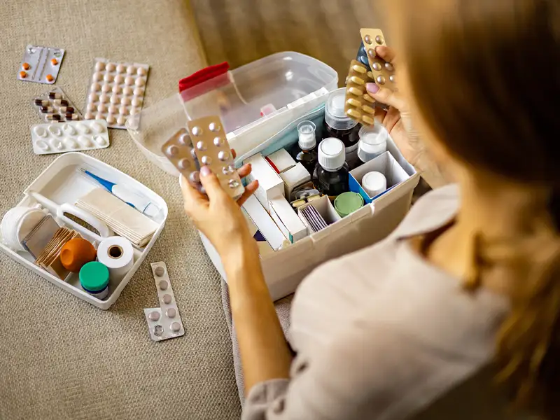 woman checking medications while sitting on her couch