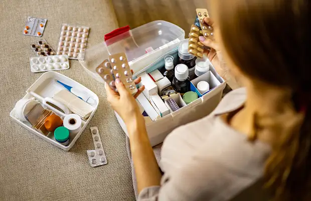 woman checking medications while sitting on her couch