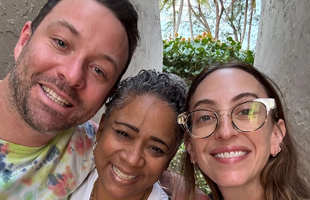 Selfie of two men and a woman smiling at the camera