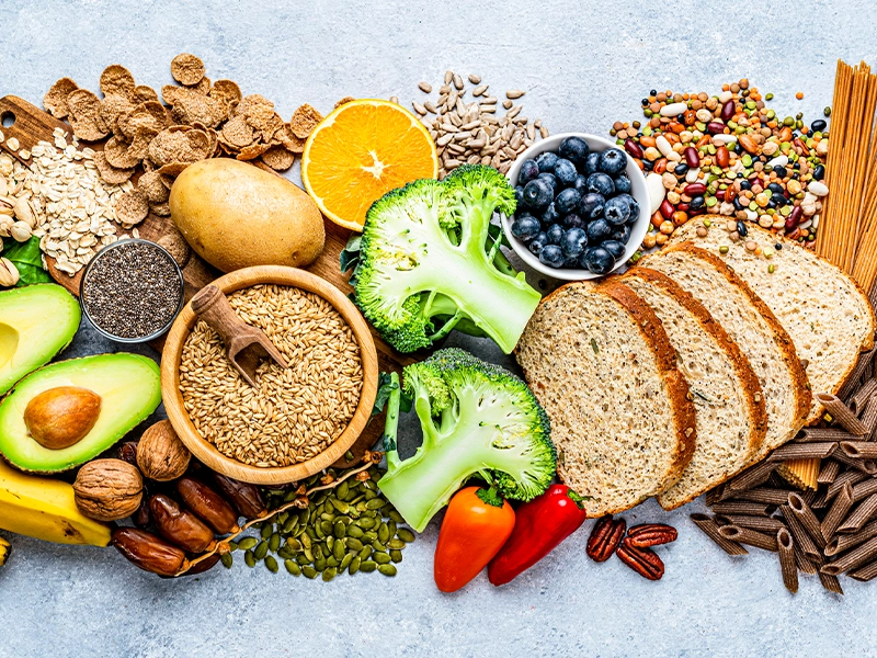An image showing oranges, grains, blueberries, bread, avocado, and other healthy foods