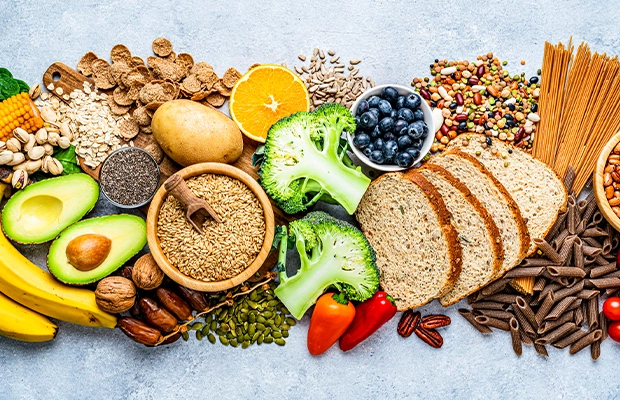 An image showing oranges, grains, blueberries, bread, avocado, and other healthy foods