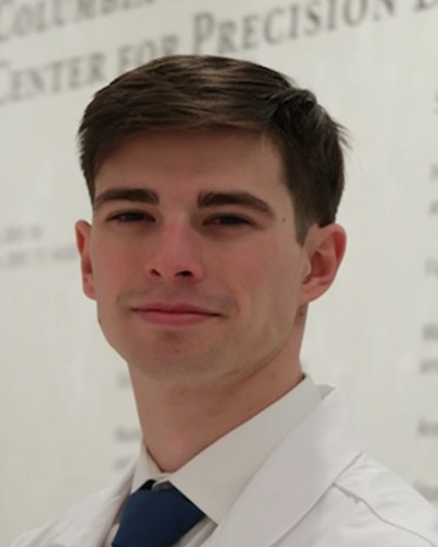Professional headshot of Luis-A-Diaz, a man smiling, against a white studio background