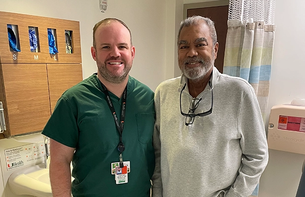 man smiling next to a doctor