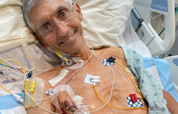 man lying on a hospital stretcher, while having different patches and tubes connected to his body,