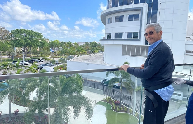 photograph of a man from a balcony next to a beautiful landscape