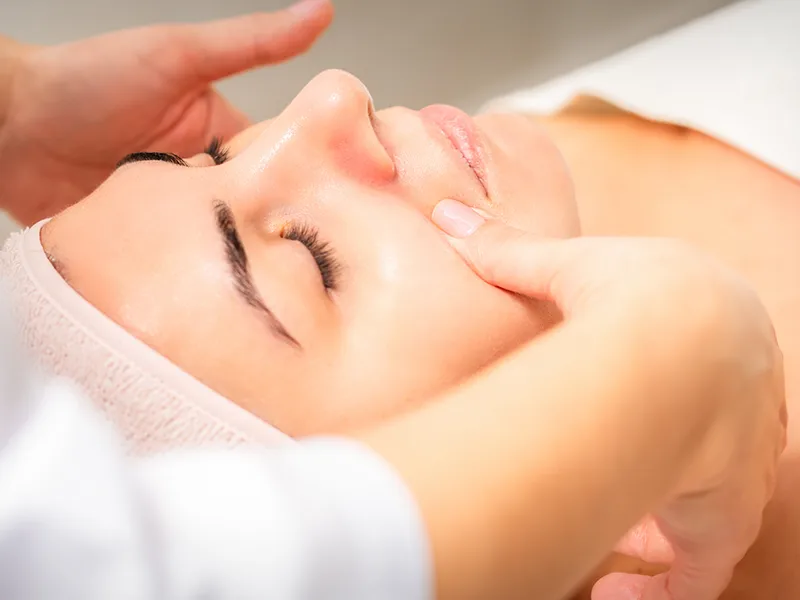 Close-up of a woman receiving a facial massage