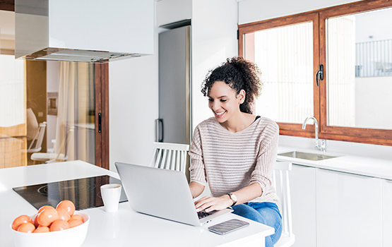 Woman using laptop computer in the kitchen