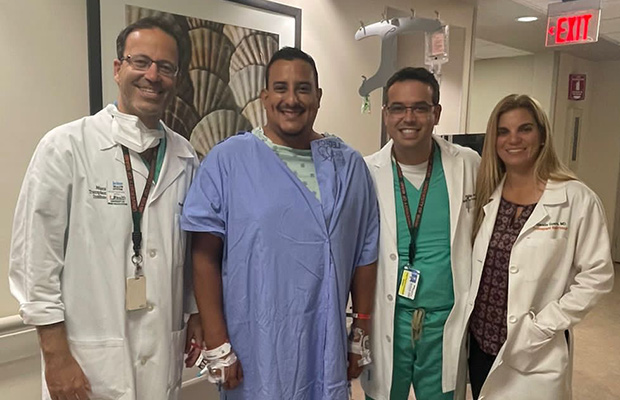 Three medical professionals and a patient smiling at the camera