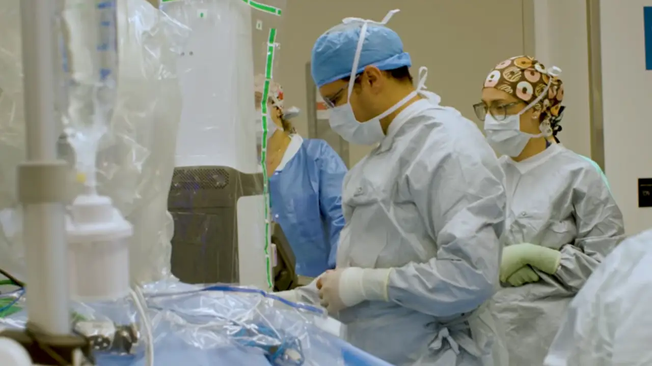 A medical team during a transplant surgery, they have on scrubs and medical masks