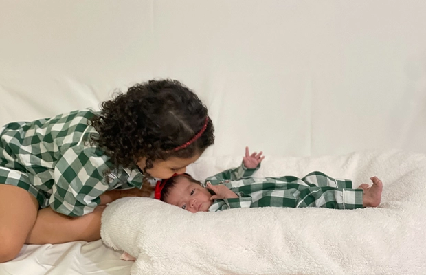girl kissing her brother's forehead