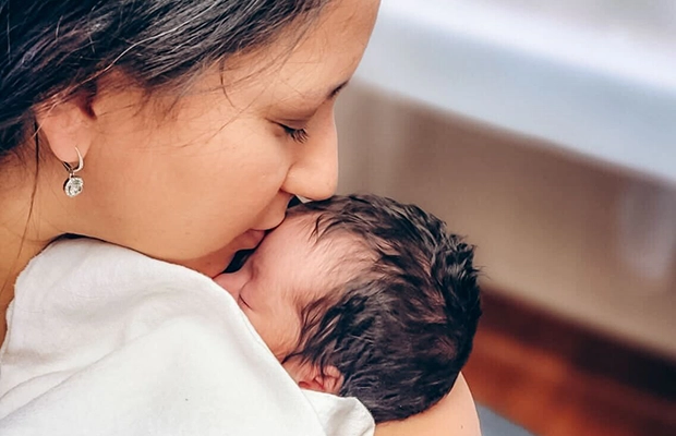 mom kissing her baby's forehead