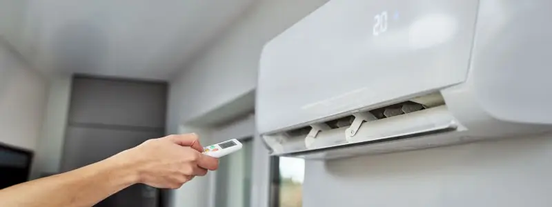 A closeup of a person turning on an air conditioner uit