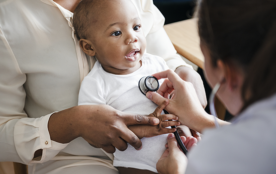 Closeup of a physician listening to a babies heart