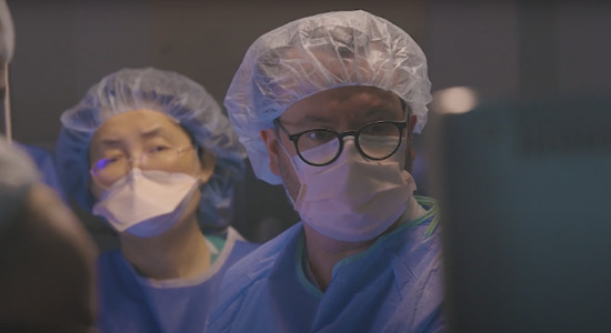 Medical professionals wearing operational gear and looking at a screen