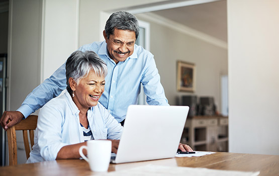 A senior couple utilizing a laptop within a home
