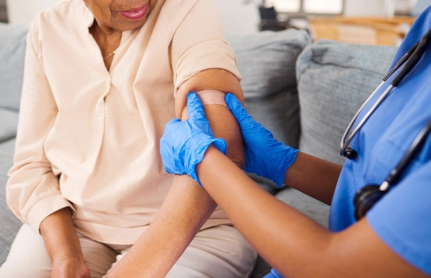 close-up of a nurse's hands bending the arm of an older woman