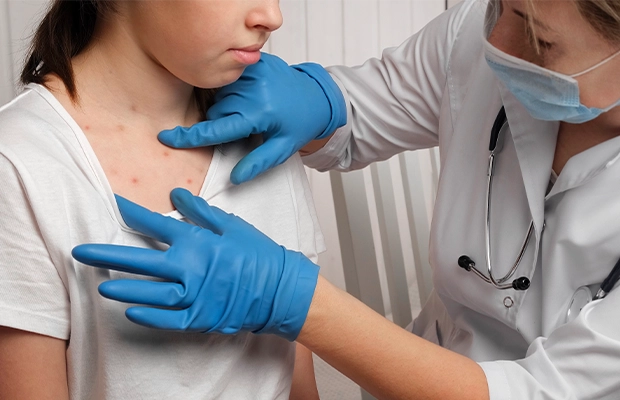 Female doctor checking the chest of a girl patient