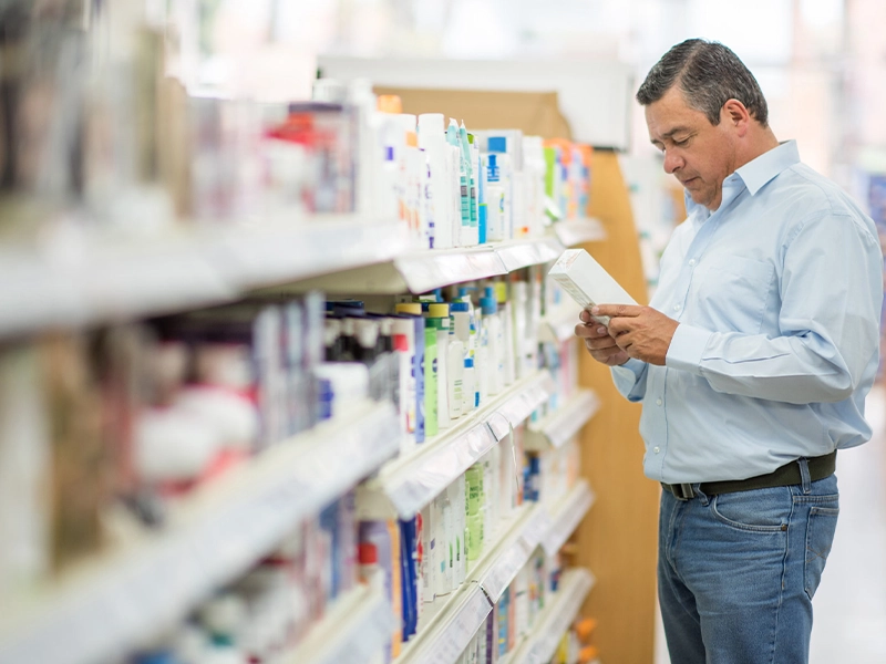 Man choosing something in front of a bookstore shelf