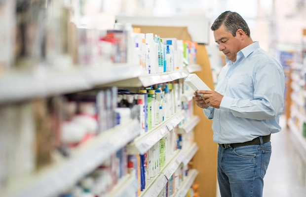 Man choosing something in front of a bookstore shelf