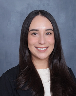 Close-up of a woman in a suit smiling at the camera.