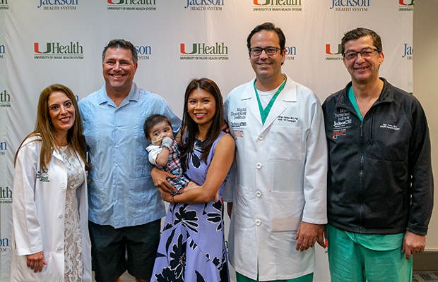 Michael David Antonio Angelo being held by his mother, surrounded by his father and his multidisciplinary team