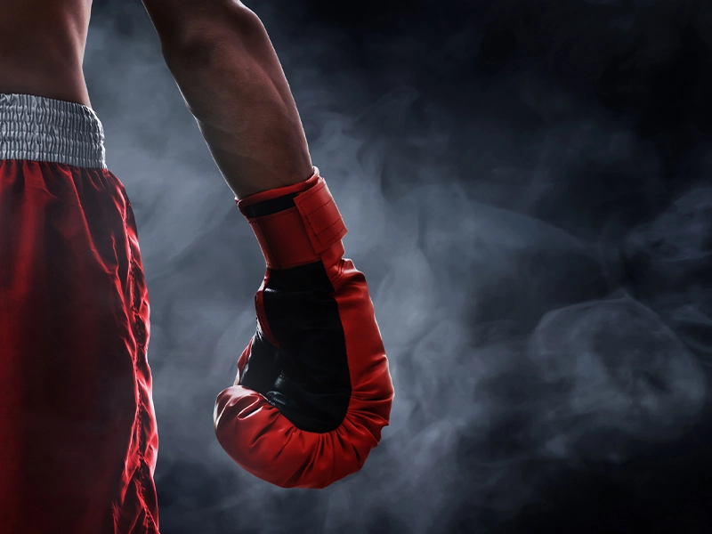 closeup of back and leg of man from behind wearing boxing gloves