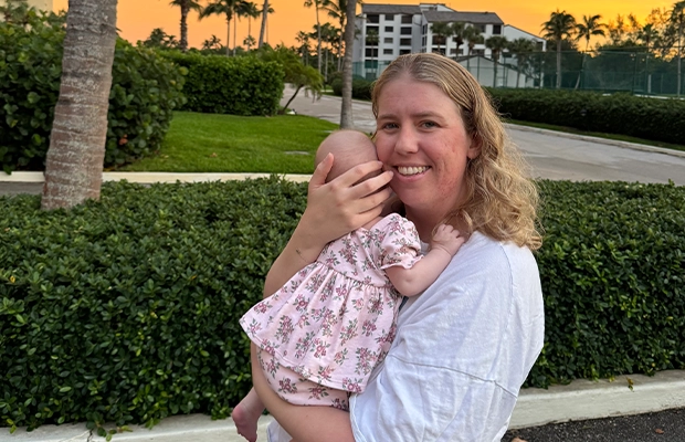 Woman carrying her baby at a beautiful sunset.