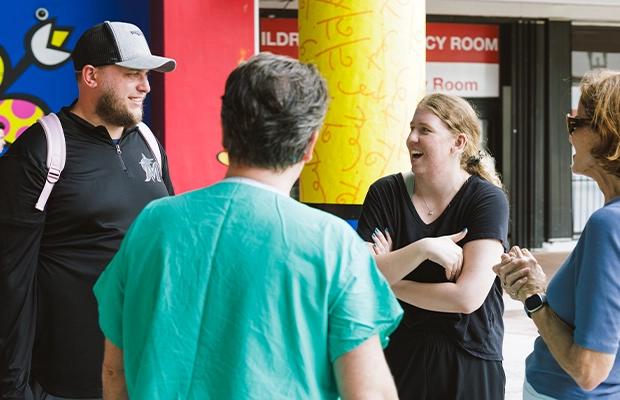 four people talking on the street