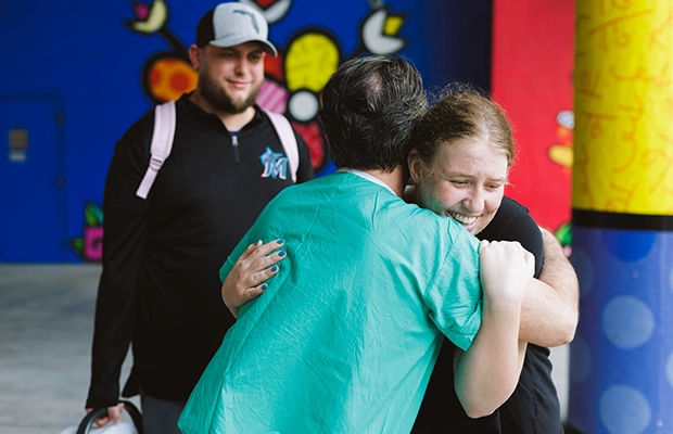 A woman hugging a doctor while smiling