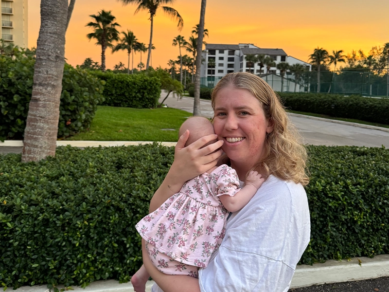 Woman carrying her baby at a beautiful sunset.