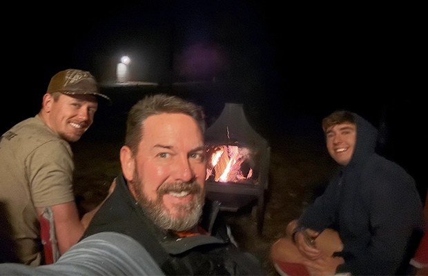 selfie of three men by a campfire