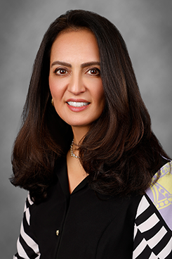 A closeup of a woman, she smiles at the camera
