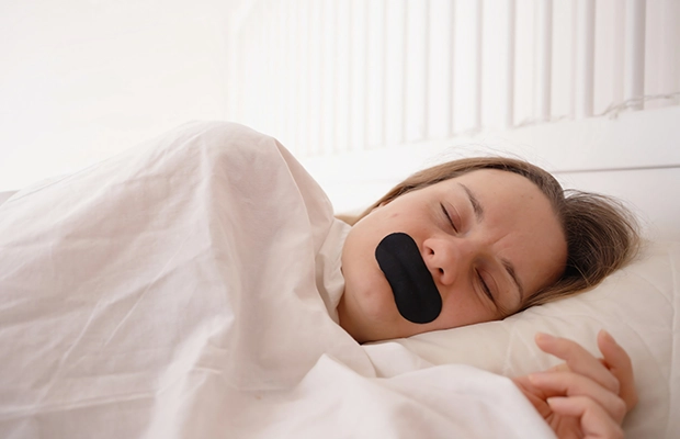 woman sleeping with a patch over her mouth