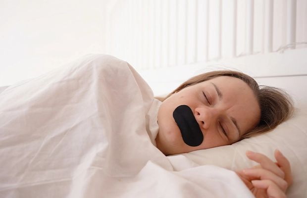 woman sleeping with a black blindfold over her mouth