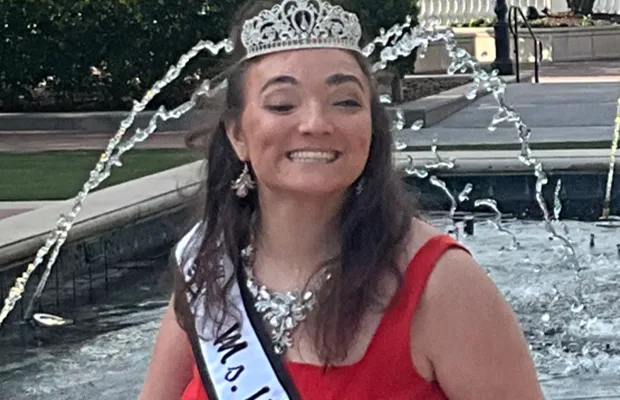 woman in red dress smiling wearing silver crown