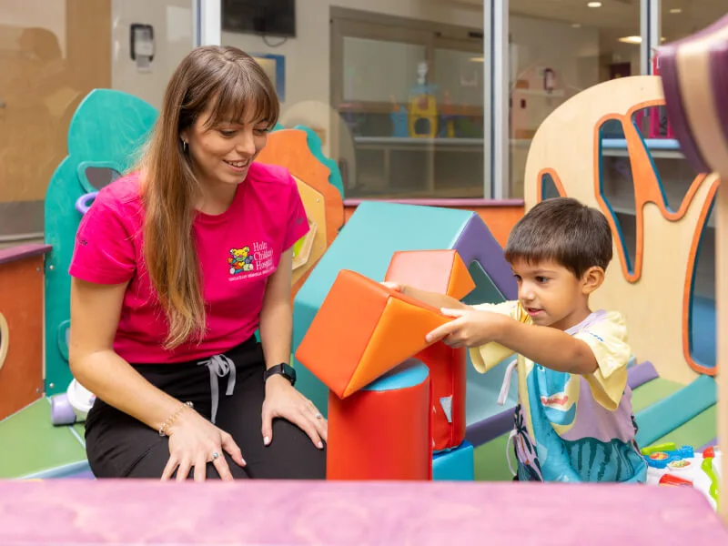 A woman playing with a young patient