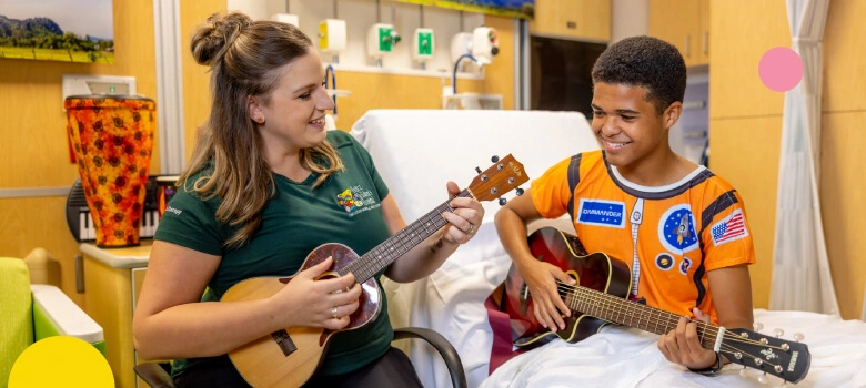 A woman and young patient playing guitars