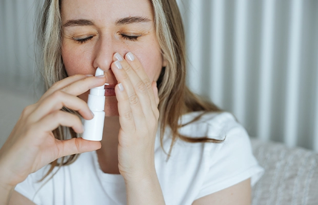 Woman using nasal spray