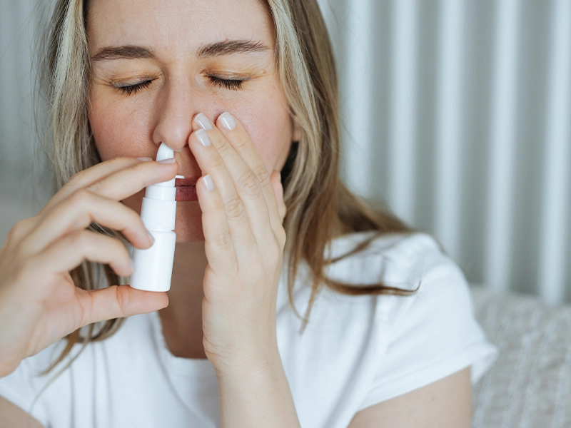 Woman using nasal spray