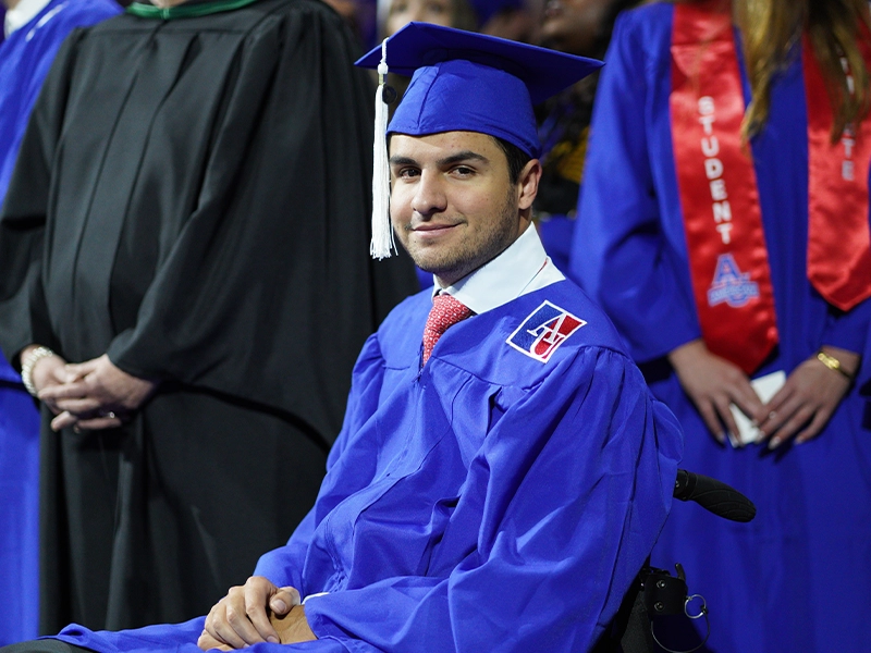 Young man smiling at camera during graduation ceremony