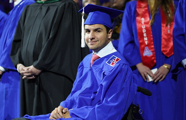 Young man smiling at camera during graduation ceremony