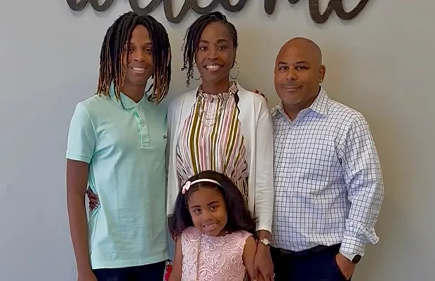 Family photo consisting of father, mother, little girl and young teenager