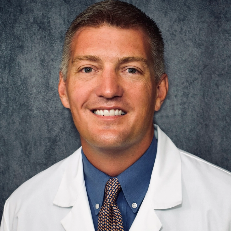 Close-up of a man wearing a doctor's coat.